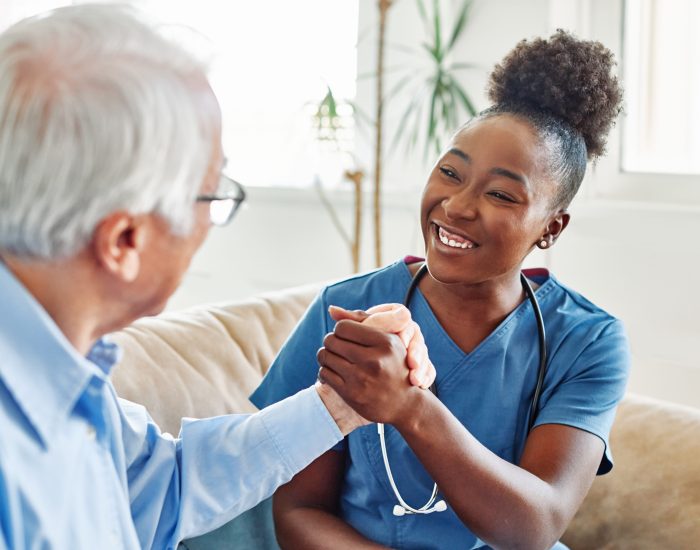 Doctor or nurse caregiver and senior man at home or nursing home